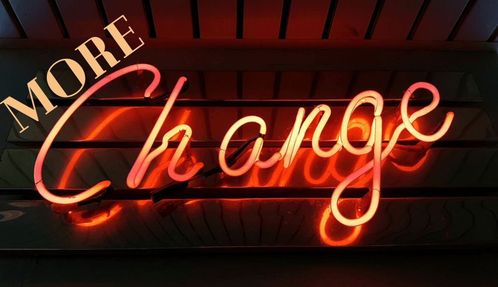 Orange neon word sign reading "change" with More above it